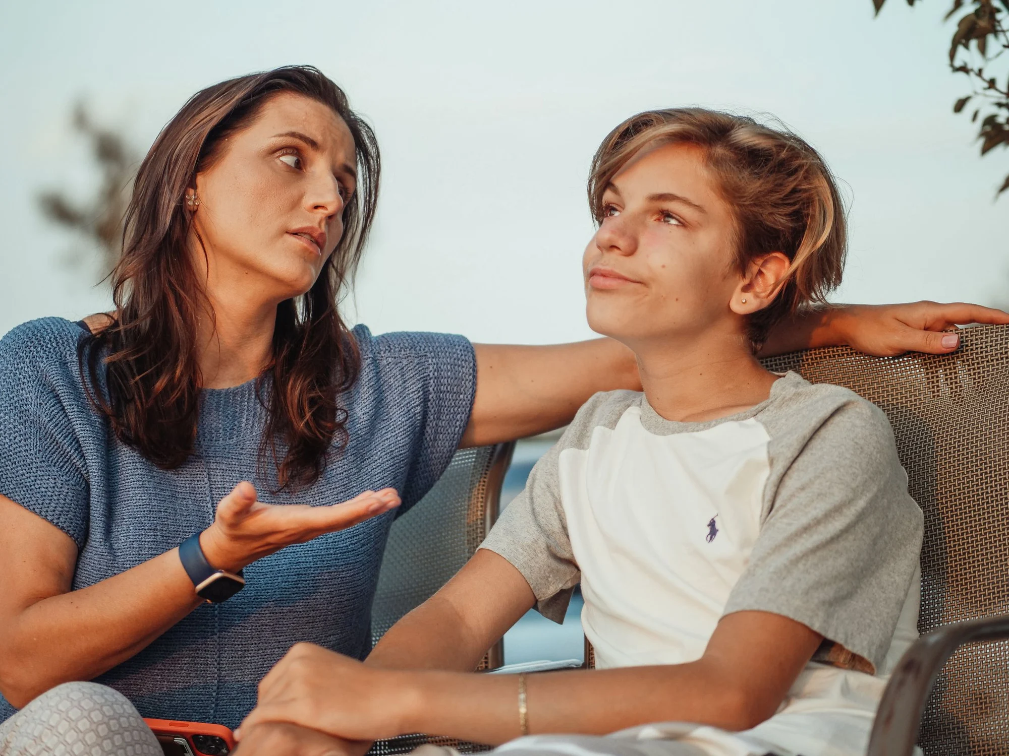 A mother and her teenage son talking together at home